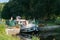 Houseboats with tourists pass through river locks on the river Oust near Josselin in Brittany