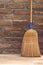 Household Broom For Floor Cleaning Leaning on Brick Wall