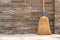 Household Broom For Floor Cleaning Leaning on Brick Wall