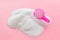 Household chemicals. Washing powder in plastic spoon on pink background