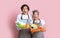 Household Chores. Portrait Of Shocked Couple Holding Buckets With Cleaning Supplies