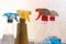 Household cleaning products in spray bottles next to a window -red, blue, yellow, chemicals, clean, copy space