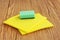 Household. Cleaning sponge and yellow micro fiber napkins on wooden background