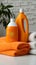 Household freshness Orange liquid washing powder bottle beside neatly folded towels