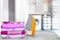 Household laundry ironing. Close-up of a yellow electrical iron and a stack of ironed clothes on white board over blurred curtains