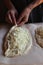 Household. Women`s hands form dough sprinkled with cheese for making khachapuri. Family celebration