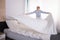 Housekeeper Arranging Bedsheet On Bed