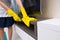 Housekeeper cleaning and dusting a TV cabinet