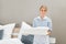 Housekeeper holding stack of sheet