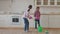 Housekeeping mixed race sisters swabbing down floor