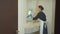 Housemaid in gloves wipe the mirror in bathroom in hotel