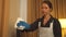 Housemaid in gloves wipe the TV with rag in hotel room