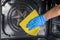 Housemaid in protective gloves washes an electric oven with a yellow rag