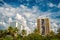 Houses on cloudy sky in miami, usa. Apartment or hotel buildings in garden with green palm trees. Architecture and real