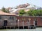 Houses and greenery behind a high fence in Venice and a sea wharf for boats with seated seagulls