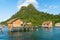 Houses made of wood and woven palm leaves in a water village against the sandstone and sedimentary rock hilltops of Tatagan Island