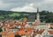 houses with red roofs and the spire of a small Gothic church in a small European town or village