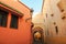 The houses in traditional pink color are on both sides of the small alley. Marrakesh