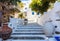 Houses whitewashed walls sunny day at Sifnos island, Greece. Stone stairs background