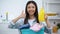 Housewife with basket full of clothes and laundry detergent showing thumbs-up