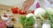 Housewife chopping a fresh red bell pepper