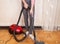 Housewife cleans the floor with a vacuum cleaner