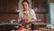 Housewife closes jars of freshly made jam with lids, standing on kitchen island