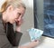 The housewife cries and counts money for repair of a window which has burst in a frost