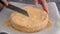 A housewife cutting a meringue nut layer cake. Making of Ukrainian Kiev Cake.