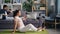 Housewife doing yoga when husband working with laptop talking on mobile phone