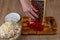 A housewife grates red beets for a vegetable salad on an iron grater. Close-up of female hands rubbing red beets for