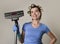 Housewife with hair rollers and gloves happy smiling cheerful holding vacuum cleaner