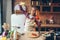 Housewife in headphones and apron dance on kitchen