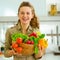 Housewife holding plate full of vegetables in modern