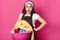 Housewife holds basin of dirty clothes, stand with opened mouth, has shocked facial expressions, dressed in brown apron and hair