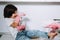 Housewife mom in pink gloves washes dishes with her son by hand in the sink with detergent. A girl in white and a child