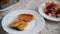 Housewife puts cheese pancakes on plate and pours raspberry jam