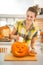 Housewife putting candle inside orange pumpkin Jack-O-Lantern