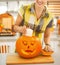 Housewife putting candle inside orange pumpkin Jack-O-Lantern