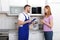 Housewife and repairman near microwave oven