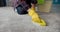 Housewife in rubber gloves cleaning carpet with brush