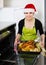 housewife in Santa hat baking festive capon