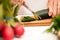 Housewife slicing cucumber in the kitchen