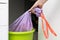 housewife takes out a garbage bag with garbage from a bucket