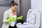 Housewife washing and disinfecting toilet, in gloves with detergent and brush