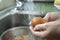 Housewife washing a raw eggs.