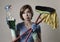 housewife in washing rubber gloves carrying cleaning spray bottle broom and mop