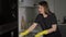 Housewife in yellow gloves washes and wipes electric stove at kitchen.