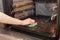 Housework and housekeeping concept. Scrubbing the stove and oven. Female hand with green sponge cleaning the kitchen oven.