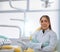 How can I help today. Portrait of a cheerful young female dentist standing with her arms folded while looking at the